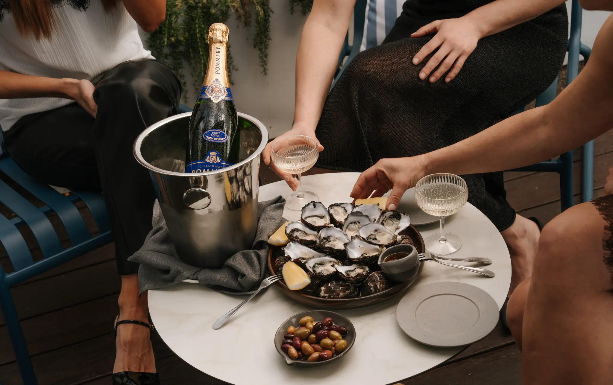 Champagne Pommery, oysters and guests gathered around a Stella table